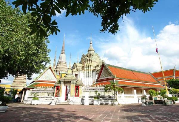 Bangkok-Thailand: voorgrond bomen en oude pagode of Chedi Thaise architectuur aan de openbare tempel Wat Pho op 22 oktober 2016 — Stockfoto