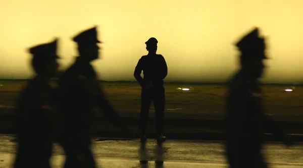 Silhouette noire sur fond mural d'un policier en uniforme, Flou photo style — Photo