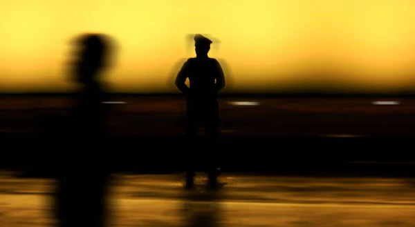 Silhouette nera sullo sfondo della parete di un agente di polizia in uniforme, Sfocatura foto stile — Foto Stock