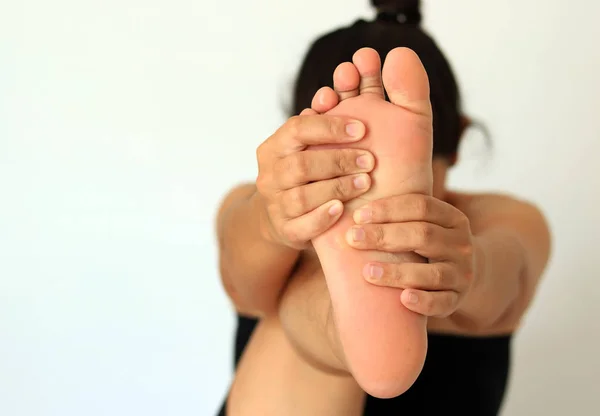 Frau massiert ihren Fuß. auf weißem Hintergrund. — Stockfoto