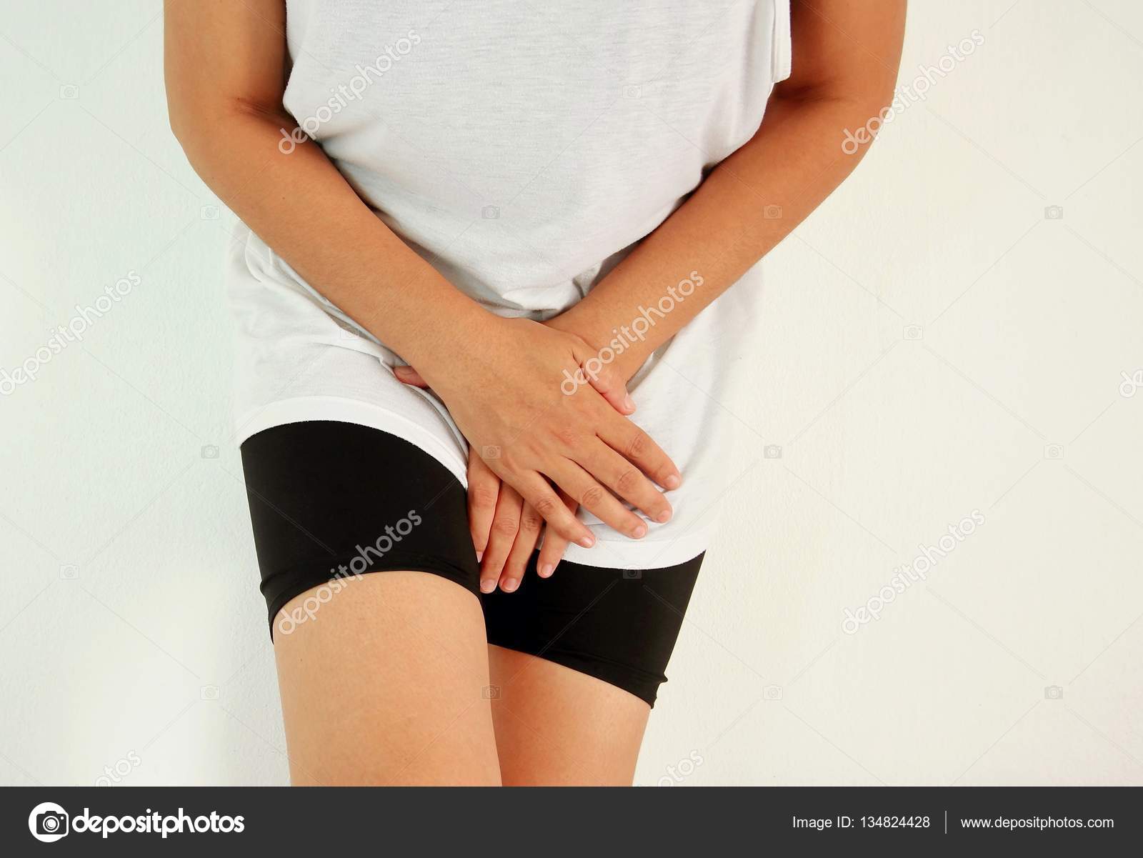 Close up of a woman with hands holding her crotch Stock Photo by