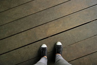 ahşap geçit üzerinde siyah spor ayakkabı