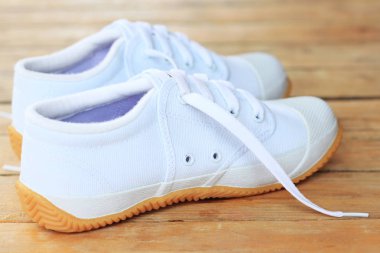 Ahşap arka plan üzerinde beyaz spor ayakkabı