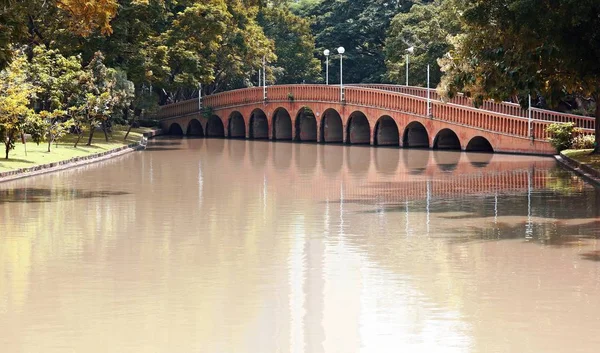 Ponte de tijolo de arco sobre o lago em Jatujak (Chatuchak) parque público da cidade — Fotografia de Stock