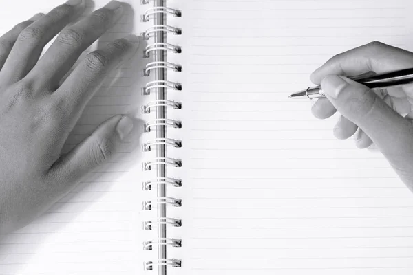 Primer plano de las manos del hombre escribiendo en cuaderno espiral — Foto de Stock