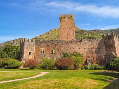 Caetani Kalesi 'nin ortaçağ kalıntıları çeşitli renklerde çiçekli muhteşem Ninfa bahçesiyle çevrilidir. Norma ve Sermoneta yakınlarındaki Monti Lepini vadisi. Güzel manzara. İtalyan manzarası.