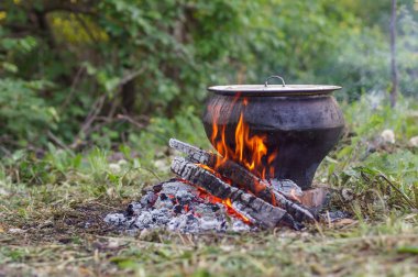 Cast iron on the fire, close-up. People resting in nature, lit a fire and cooked on it in fish soup.