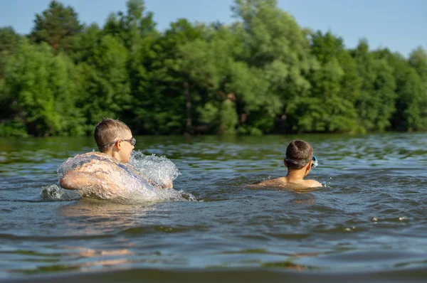 Les adolescents éclaboussent tout en nageant dans le lac — Photo