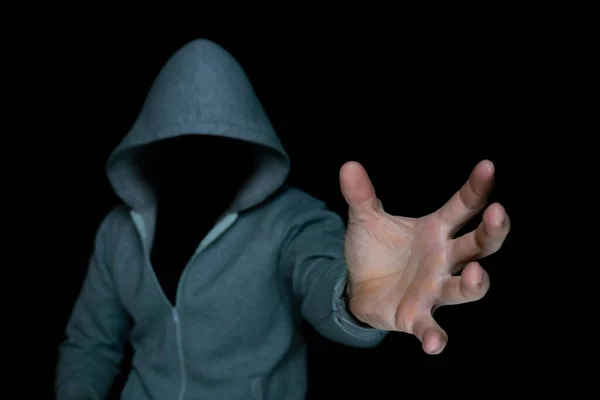 An unknown criminal pulls his hand out of the darkness. Computer hacker tries to steal data. — Stok fotoğraf