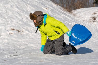 Çocuk, kışın sokakta oynarken eğleniyor..
