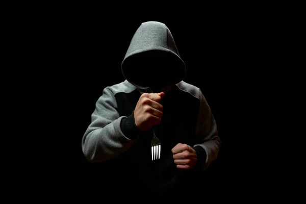Maniático desconocido con un tenedor en la mano, sobre un fondo negro — Foto de Stock