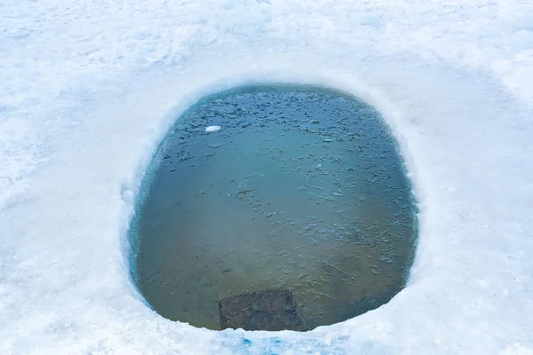 Bir kış günü donmuş bir gölde buz deliği. — Stok fotoğraf