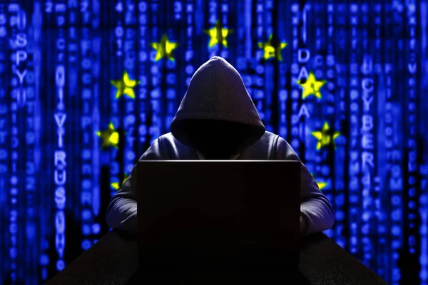 Avrupa 'dan siber tehdit. Bilgisayardaki Avrupalı hacker, ikili kodların arka planında, Avrupa Birliği bayrağının renkleri. DDoS saldırısı
