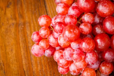 ahşap arka plan üzerinde kırmızı üzüm