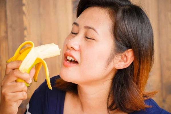 Young woman showing banana