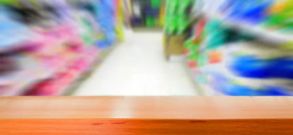 Mesa de madeira com imagem borrada de supermercado — Fotografia de Stock
