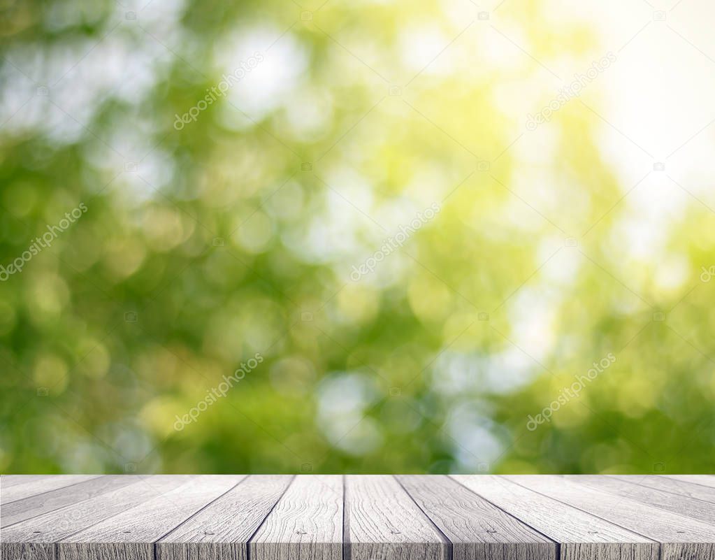 Wooden tabletop with fresh green nature blurred background