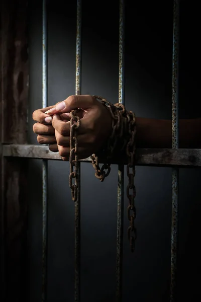 Заключенный с цепью, держащий тюремный бар — стоковое фото