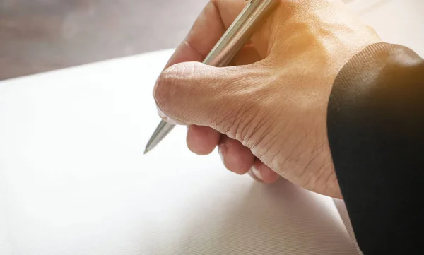 Empresario escribiendo algo en papel — Foto de Stock