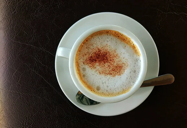 Cappuccino-Tasse auf dunklem Holz aufgesetzt — Stockfoto