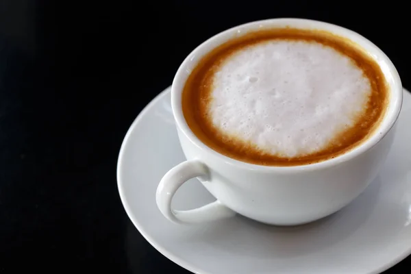 Cappuccino-Tasse auf dunklem Holz aufgesetzt — Stockfoto