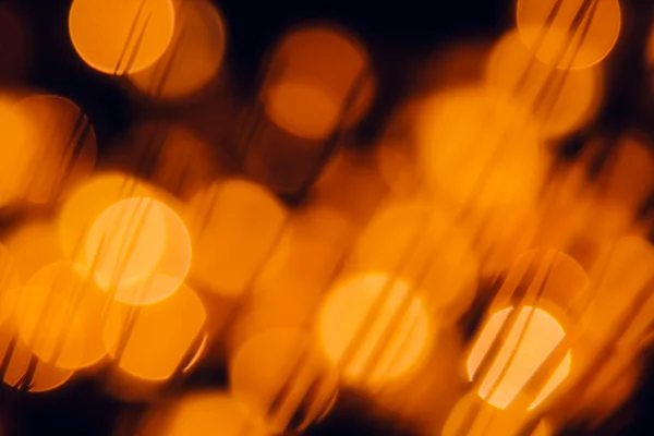 Bokeh cerchi arancio scuro e ombra erbe su sfondo nero . — Foto Stock