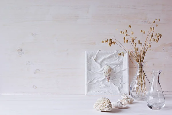 Weiche Wohnkultur. Muscheln und Glasvase mit Stacheln auf weißem Holzhintergrund. — Stockfoto