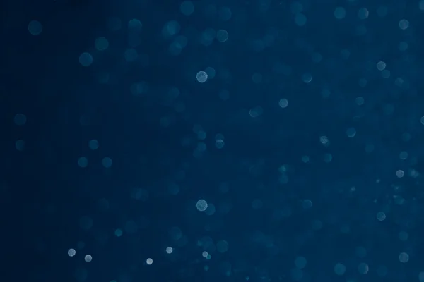 Bokeh dunkelblauer Hintergrund mit verschwommenen Regenbogenlichtern. — Stockfoto