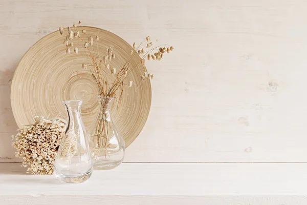 Decoración suave para el hogar de jarrón de vidrio con espiguillas y placa de madera sobre fondo de madera blanca . — Foto de Stock
