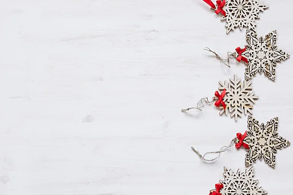 Flocons de neige en bois beige doux de Noël sur un fond blanc en bois . — Photo