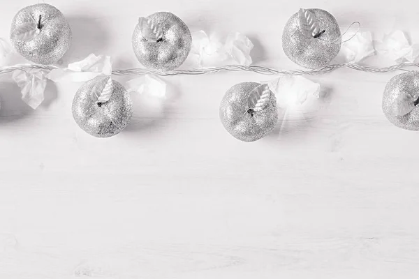 Christmas silver apples decoration and burning lights on wooden white background. — Stock Photo, Image