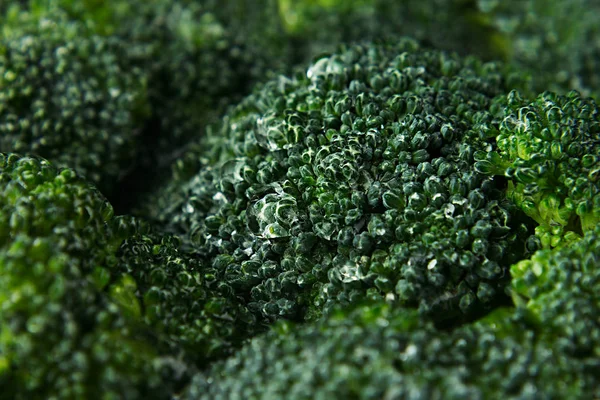 Brócolis verde fresco molhado com gotas de água close-up como fundo . — Fotografia de Stock