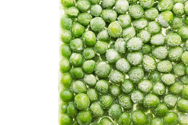 Border of fresh frozen green peas with hoarfrost closeup on white background. — Stock Photo, Image