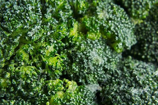 Brócolis verde fresco molhado com gotas de água close-up como fundo . — Fotografia de Stock