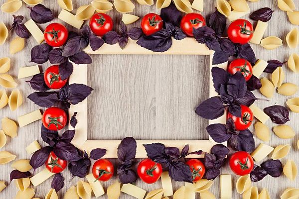 Ingredientes Pasta italiana - tomates, albahaca, queso, macarrones sobre tabla beige con espacio de copia vacío como fondo decorativo . — Foto de Stock