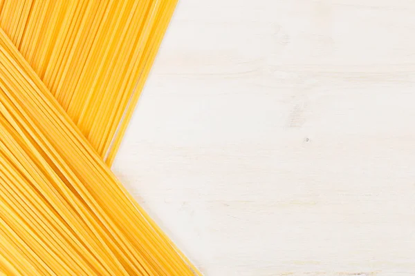 Borde decorativo de espagueti italiano largo con espacio de copia sobre fondo de madera blanca . — Foto de Stock