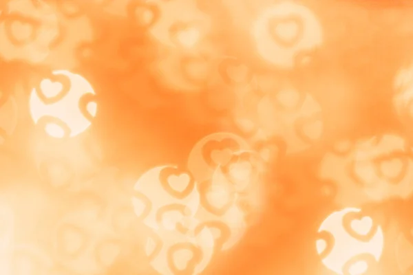 Valentinstag abstrakte Hintergrund der weichen orangefarbenen Bokeh verschwimmen Herzen. Festliche Valentinskulisse. — Stockfoto