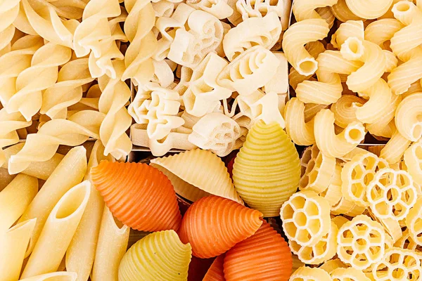 Pasta surtido de fondo de diferentes tipos de macarrones italianos en celdas de ajedrez vista superior . — Foto de Stock