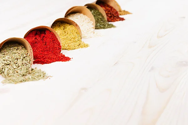 Asiatiska färgglada pulver kryddor som närbild på vit träskiva med kopia utrymme. — Stockfoto