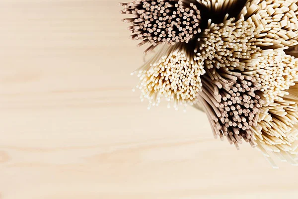 Section  of raw asian noodles top view close up on soft beige wooden board. — Stock Photo, Image
