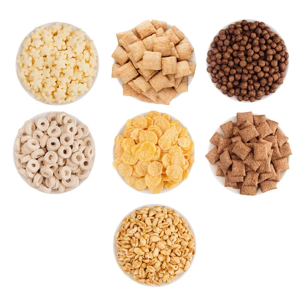 Colección de copos de maíz en cuencos blancos, vista superior, aislado sobre fondo blanco. Los cereales para el desayuno establecen diferentes formas y sabores . — Foto de Stock