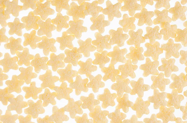 Gele sterren cornflakes close-up op witte achtergrond, textuur van de granen. Bovenaanzicht. — Stockfoto