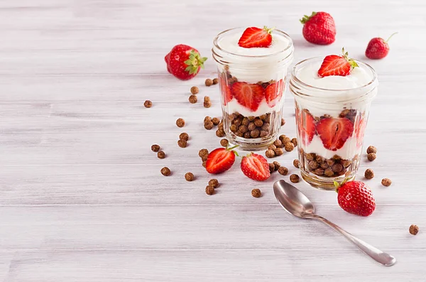 健康早餐与巧克力球玉米片，白的木头板上的切片草莓. — 图库照片