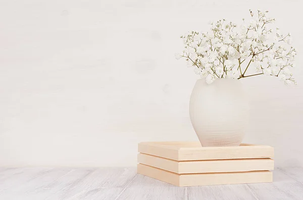 Decoración suave para el hogar de pequeñas flores blancas en jarrón de cerámica sobre fondo de madera blanca . — Foto de Stock