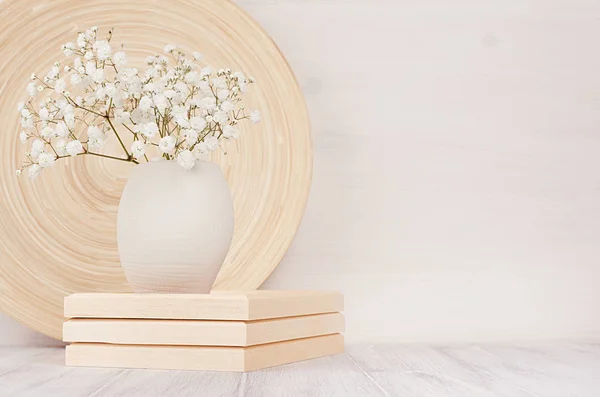 Weiches Wohndekor aus beiger Bambusschale und weißen kleinen Blumen in Keramikvase auf weißem Holzhintergrund. Innenraum. — Stockfoto