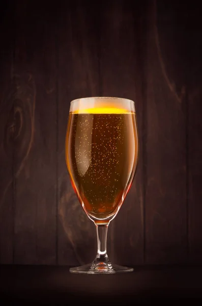 어두운 나무 보드, 수직 라 반짝이 거 황금 잔 맥주 유리. — 스톡 사진