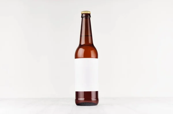 Brun longneck öl flaska 500ml med Tom vit etikett vit trä ombord, håna. — Stockfoto