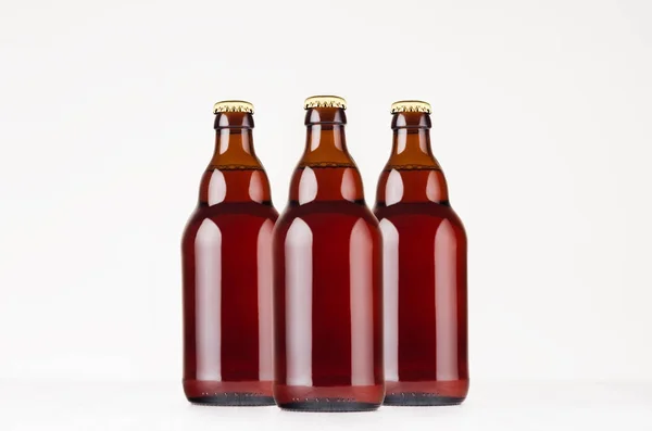 Bottiglie di birra belghe Steinie marrone di gruppo 330ml modello up. Modello per pubblicità, design, identità di branding su tavolo in legno bianco . — Foto Stock