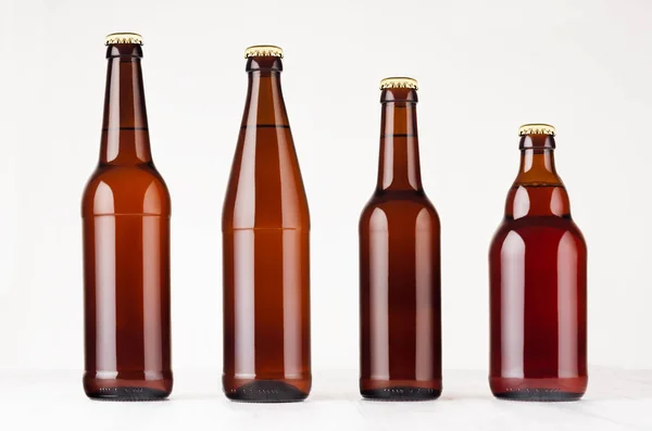 Collezione diverse bottiglie di birra marrone, mockup. Modello per pubblicità, design, identità di branding su tavolo in legno bianco . — Foto Stock