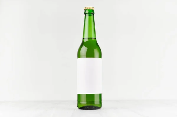 Bottiglia di birra verde collo lungo 500ml con etichetta bianca bianca bianca su cartone di legno bianco, modello up. Modello per la pubblicità, il design, l'identità di branding . — Foto Stock